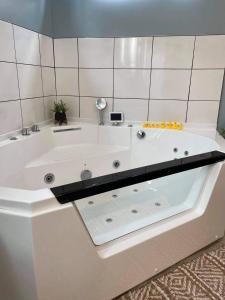 La salle de bains est pourvue d'une grande baignoire blanche. dans l'établissement Relaxing Suite For Two With Jacuzzi, à Pacific