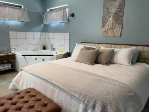 a bedroom with a large bed and a sink at Relaxing Suite For Two With Jacuzzi in Pacific