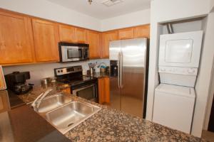 a kitchen with a stainless steel refrigerator and a sink at Fiddler on the Reef at Playa Rana in Virginia Beach +1 photo