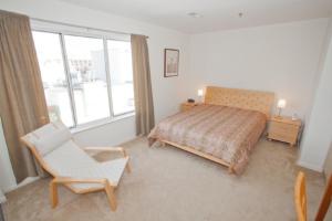 a bedroom with a bed and a chair and a window at Fiddler on the Reef at Playa Rana in Virginia Beach