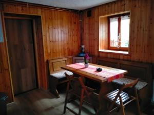Habitación de madera con mesa, sillas y ventana en Casa dei sogni, en Aosta