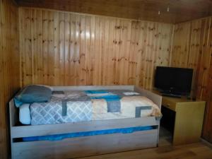 1 dormitorio con 1 cama y escritorio con TV en Casa dei sogni, en Aosta