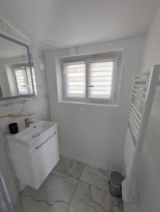 a white bathroom with a sink and a mirror at *J'y suis j'y reste* - proche de Paris in Villejuif