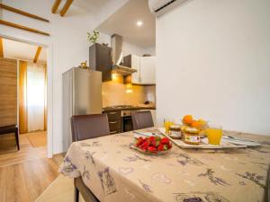 a kitchen with a table with a bowl of fruit on it at House Green Oaza in Zadvarje