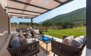 een patio met banken en een tafel met uitzicht bij House Madonna di Smovo in Gata