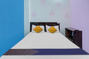 una camera da letto con un grande letto con cuscini gialli di SPOT ON 81083 Sky Villa Hotel a Patna
