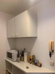 a kitchen counter with a microwave and a white cabinet at Studio Heidelberg in Heidelberg