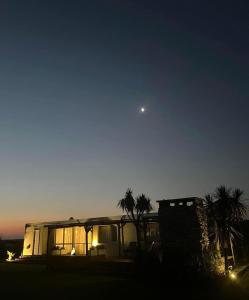 Ein Haus mit Palmen und dem Mond am Himmel in der Unterkunft Grand Zen Hotel in Loma Verde