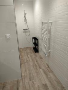 baño con ducha y suelo de madera. en Maison de vacances 3 chambres, en Locquirec