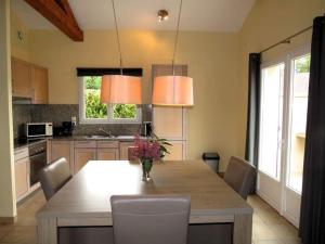 a kitchen with a large wooden table with chairs at French Country Villas in Les Forges