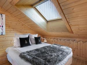 sypialnia z łóżkiem w drewnianym domku w obiekcie Duplex Moderne à Méribel : Ski aux Pieds, Piscine et Spa Inclus - FR-1-566-55 w mieście Les Allues