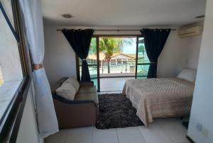 1 dormitorio con cama y ventana con vistas en Chalé na praia de Barreta, en Nísia Floresta