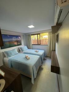 a bedroom with two beds and a table at Barra Grande Exclusive Residence in Barra Grande