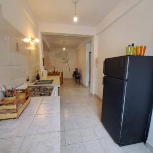 uma cozinha com um frigorífico preto num quarto em Torre Armonia em San Salvador de Jujuy