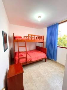 two bunk beds in a room with a window at Casa con piscina y salida a la playa in Playas