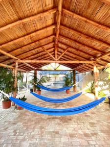 un grupo de bancos azules bajo un techo de madera en Casa con piscina y salida a la playa en Playas