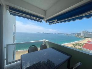 a balcony with a table and a view of the beach at CAMELIA Y MAGNOLIA ACAPULCO in Acapulco