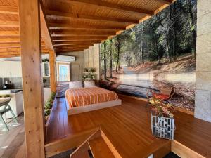 a bedroom in a house with a mural of a forest at Casas das Olas in Arcos de Valdevez