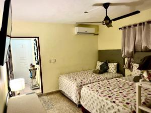 a bedroom with two beds and a ceiling fan at Hotel Maria Bonita Higüey in Higuey
