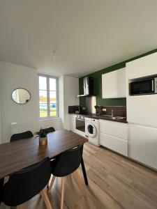 a kitchen with a table and chairs in a room at Le Duplex Tout Confort in Bressuire