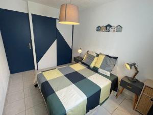 - une chambre dotée d'un lit avec une couverture bleue et blanche dans l'établissement Jolie charmant T3 refait à neuf à Marseille, à Marseille