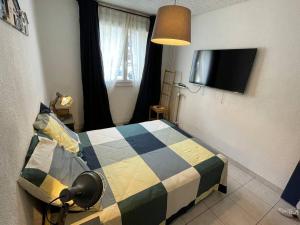 - une chambre avec un lit et une couverture colorée dans l'établissement Jolie charmant T3 refait à neuf à Marseille, à Marseille