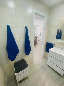 Carpe Diem في كوستا تاغيسي: حمام به مناشف زرقاء على الحائط ومغسلة