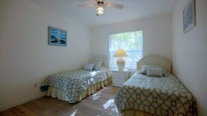 a bedroom with two beds and a window at House Rosa Downtown in Cape Coral +21 photos