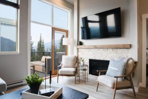 uma sala de estar com lareira e televisão em New! Luxury, Top Floor, Ski in/Ski Out, Private Hot Tub and Mountain Views em Sun Peaks