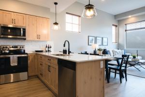 a kitchen with a sink and a counter top at New! Luxury, Top Floor, Ski in/Ski Out, Private Hot Tub and Mountain Views in Sun Peaks