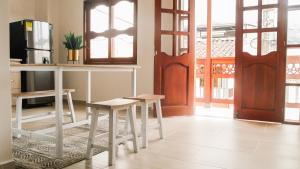 a room with a table and two stools and a refrigerator at OCASSO JARDIN APARTAMENTO AZULEJO in Jardin