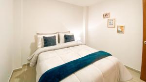 a bedroom with a large white bed with blue pillows at OCASSO JARDIN APARTAMENTO AZULEJO in Jardin