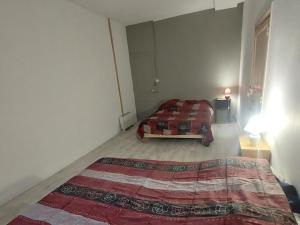 a bedroom with a bed in the corner of a room at Les hortensias studio 6 in Bourbonne-les-Bains