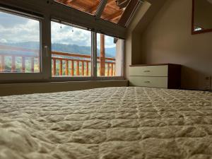 a bedroom with a large bed with a large window at Alpine Nest: 6km to ski slopes in Beli Iskar