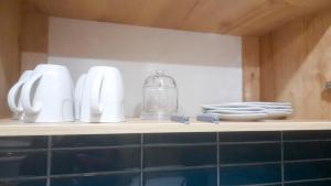 un estante con platos blancos y un frasco de cristal. en Apartamento Luz de Luna2, en La Paz