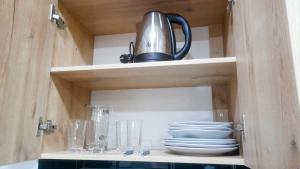 un armario con tetera, platos y vasos en Apartamento Luz de Luna2, en La Paz
