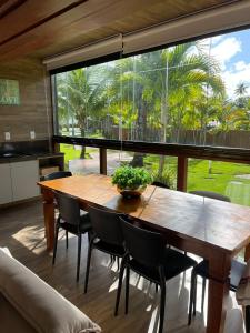 uma sala de jantar com mesa e cadeiras e uma grande janela em Barra Grande Exclusive Residence em Barra Grande