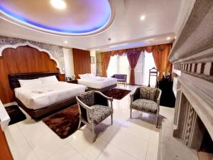 um quarto de hotel com duas camas e uma lareira em Hotel Troya em Ibarra
