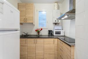 a kitchen with wooden cabinets and a white microwave at Sagrada Familia Avenida Gaudi Views&cozy Lounge in Barcelona