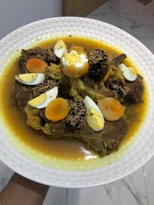 un piatto di alimenti con uova e carne di Maison d'hôte Riad Tounfite 