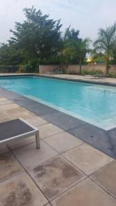 una piscina azul con un banco al lado en Contemporary 1 bedroom with pool, en Accra