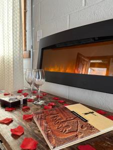 a table with two wine glasses and a fireplace at Pousada do Rei Arthur in Lavras Novas