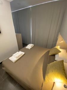 ein Schlafzimmer mit einem großen Bett mit zwei Handtüchern darauf in der Unterkunft Little House in Reggio di Calabria