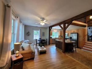 a living room with a couch and a table and a kitchen at Quiet Country Farmhouse in Suwanee