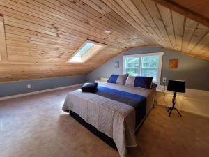 sypialnia z dużym łóżkiem i drewnianym sufitem w obiekcie Quiet Country Farmhouse w mieście Suwanee