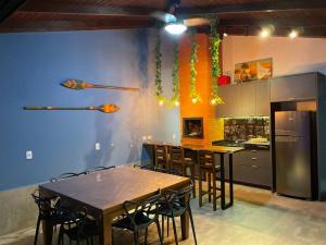 eine Küche mit Tischen und Stühlen und eine Küche mit blauen Wänden in der Unterkunft Casa com piscina em Itapema próximo a praia in Itapema