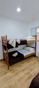 two bunk beds in a room with a wooden floor at Casa da Lú - Praia e Piscina in Praia Grande