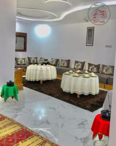 un soggiorno con 2 tavoli e un divano di Maison d'hôte Riad Tounfite 