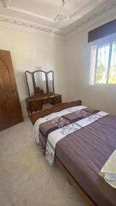 a bedroom with two beds and a mirror on the wall at Big appartement in ksar sgher and close in Ksar es Sghir