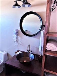 baño con lavabo y espejo en la pared en Grape Valley Old West Cabins, en Ensenada